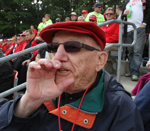 Photo of Fr. Wilfred in the stands at SJU cheering for the Johhnies