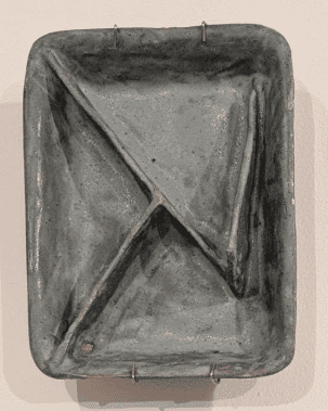 A rectangular, gray ceramic tray with three unequally sized compartments divided by raised ridges. Four small metal hooks are attached to the tray’s edges, possibly for hanging. The surface appears slightly textured and handmade.
