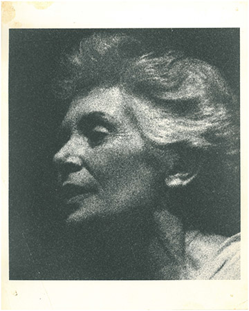 A grainy, side profile black and white photograph of an older person with wavy hair, set against a dark background. The person is looking slightly upward with a calm expression.