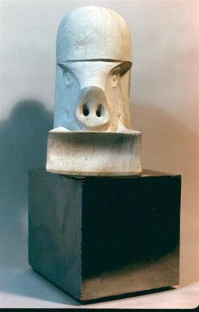A marble sculpture resembling a stylized pig's head with a prominent snout and nostrils, set on a rectangular base and displayed on a dark, square pedestal.
