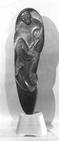 A smooth, elongated sculpture depicting a stylized figure cradling a smaller figure in its arms, both with gentle facial features, mounted on a round, light-colored base.