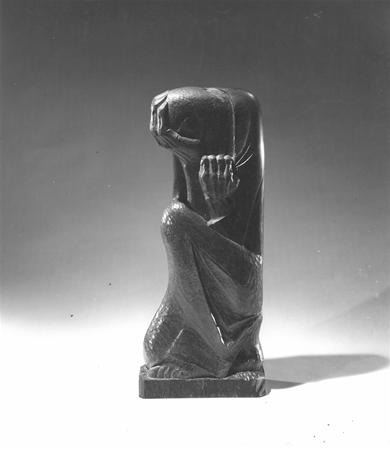 A dark, abstract sculpture of a crouching, headless human figure with one arm bent and hand raised to where the head would be, set against a plain background.