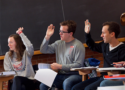 Photo of students raising their hands in a classroom
