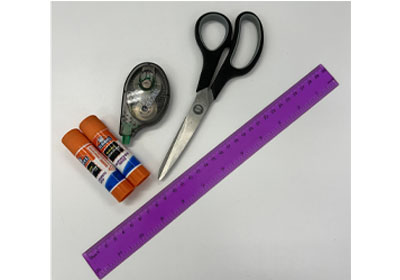 A pair of black scissors, a purple ruler, two glue sticks, and a correction tape dispenser arranged on a white surface.
