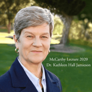 Portrait of a woman with short gray hair, wearing a dark blazer and light blue shirt, standing in a green outdoor setting. Text on the image reads, "McCarthy Lecture 2020 Dr. Kathleen Hall Jamieson.