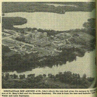 An aerial view of a scenic landscape with a river, trees, and buildings, including St. Mary's Hall and the Diocesan House. The image is grainy and monochrome, with text below describing it as a new aspect of St. John's surroundings.