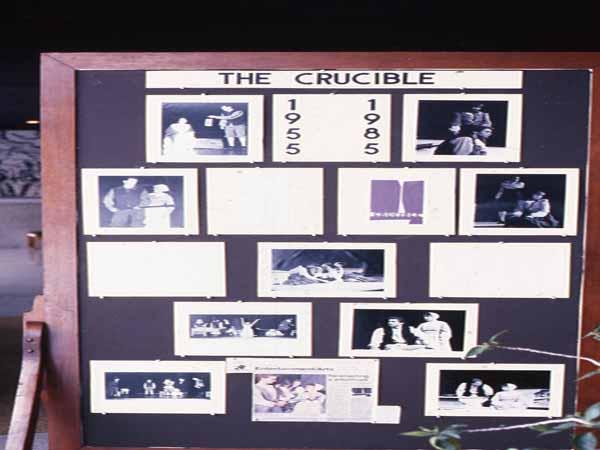 A display board titled "The Crucible" featuring photos from different productions. Years highlighted are 1955 and 1985. The board has various black-and-white images of scenes and actors from the play.