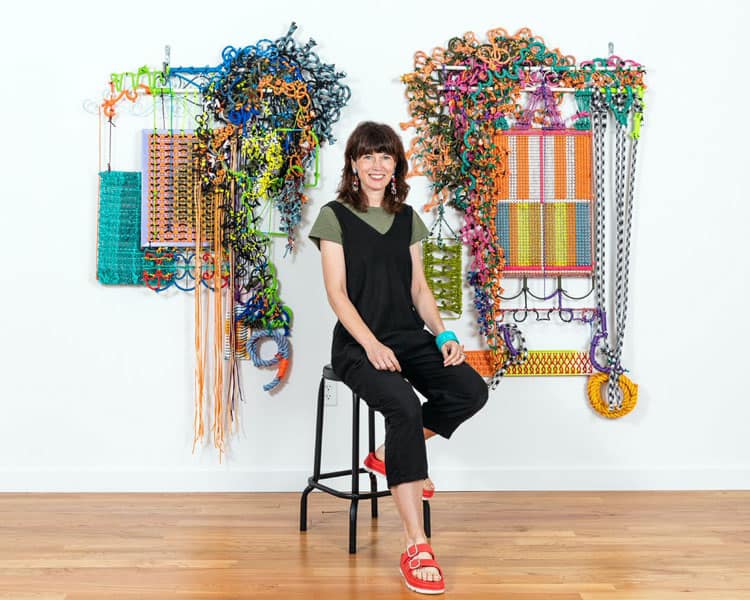 Liz Miller in front of some of her art samples.